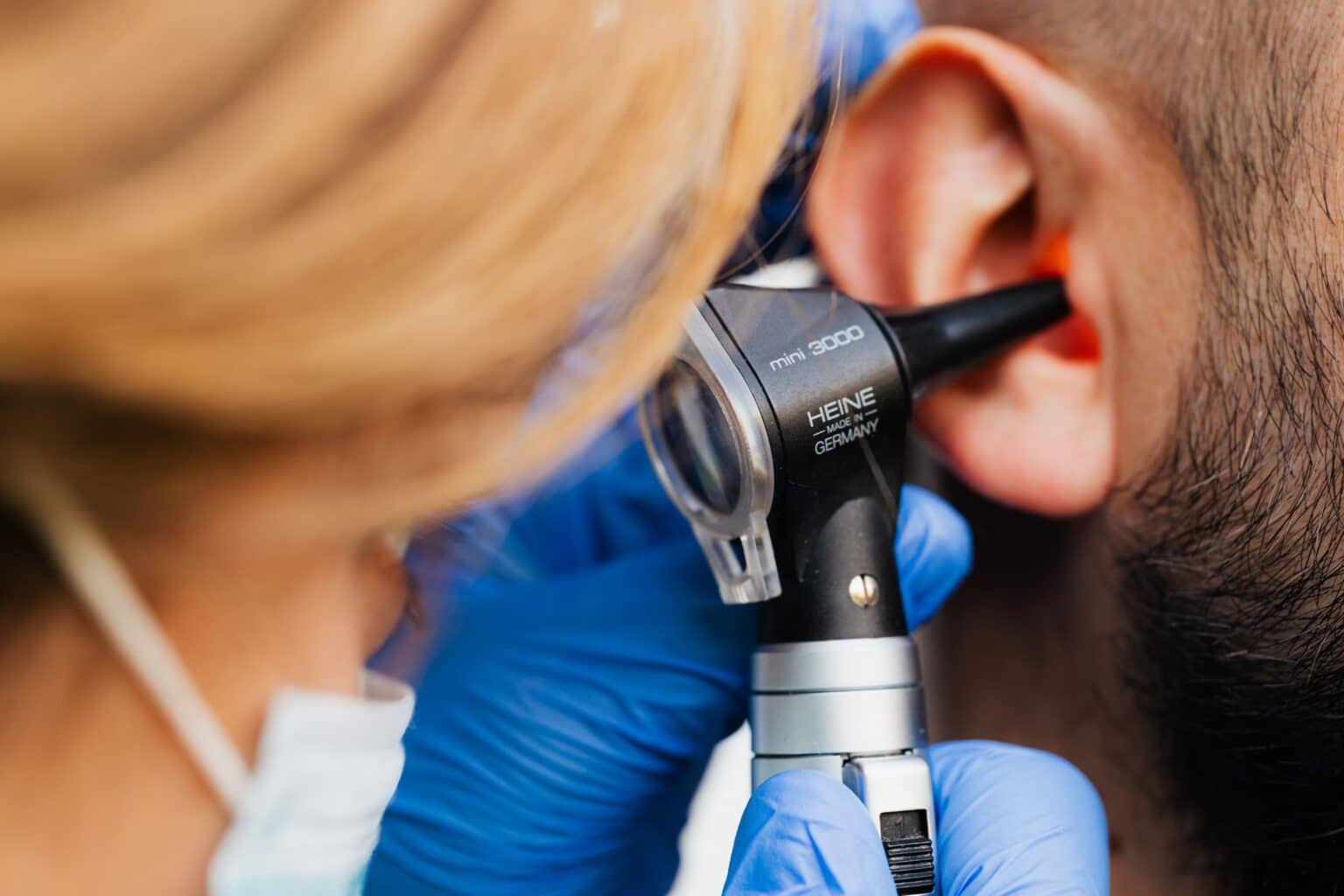 Doctor examining a man's ear.