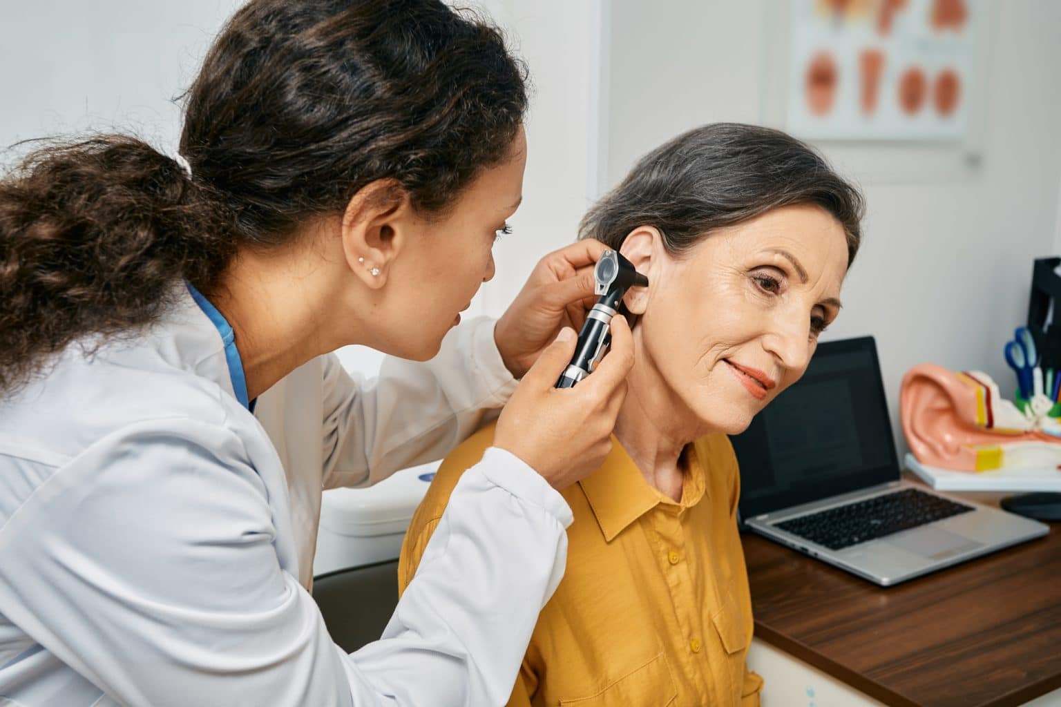 Senior woman having her ears examine by a doctor to check for hearing loss.