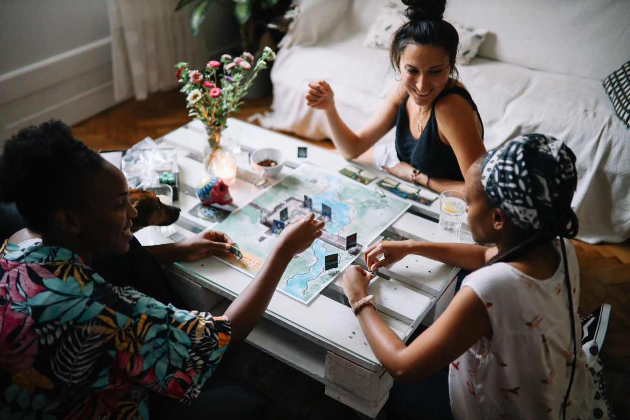 Three friends playing a board game.